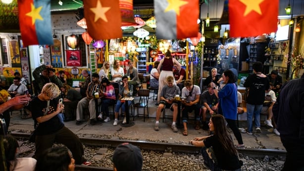 Tourists take photos along a railway track in Hanoi 
