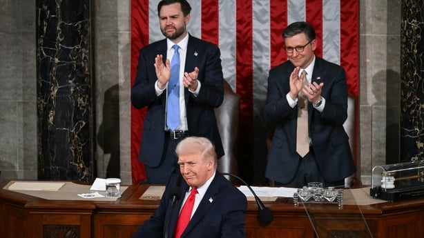 Donald Trump delivers the State of the Union address in the House Chamber of the US Capitol in Washington, DC while people appload