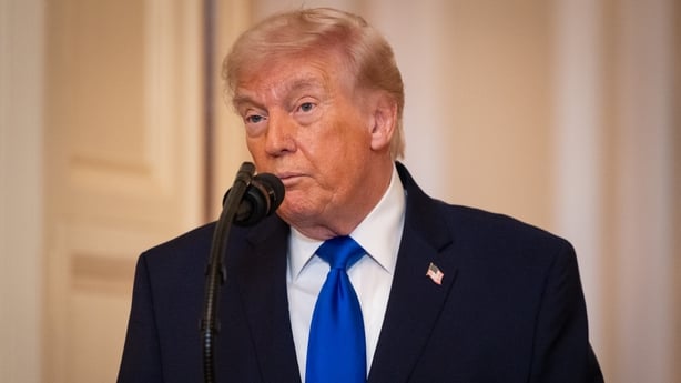 a photograph of US President Donald Trump speaking into a microphone