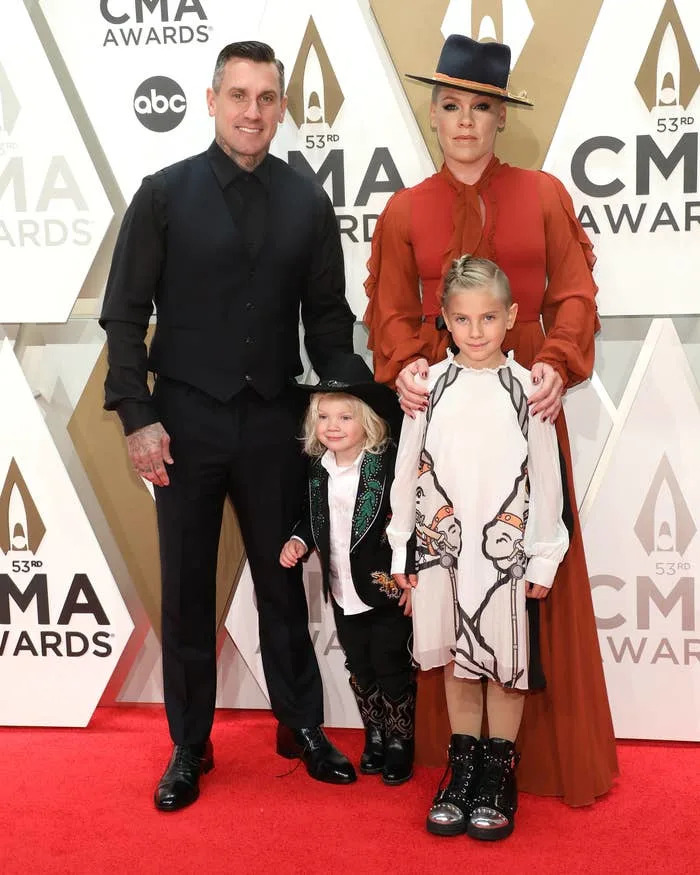 Pink and her family poses on the red carpet at the CMA Awards