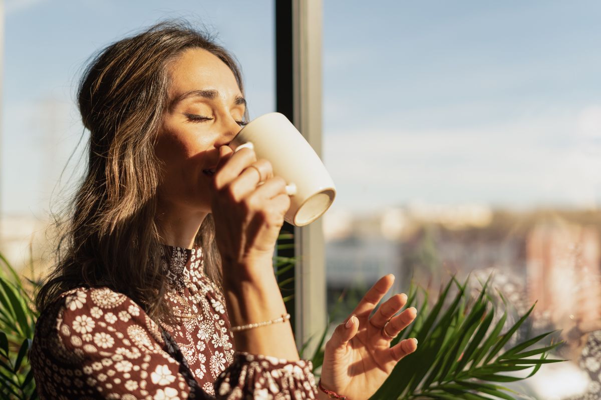 Closeup portrait of woman drinking coffee in the morning at home