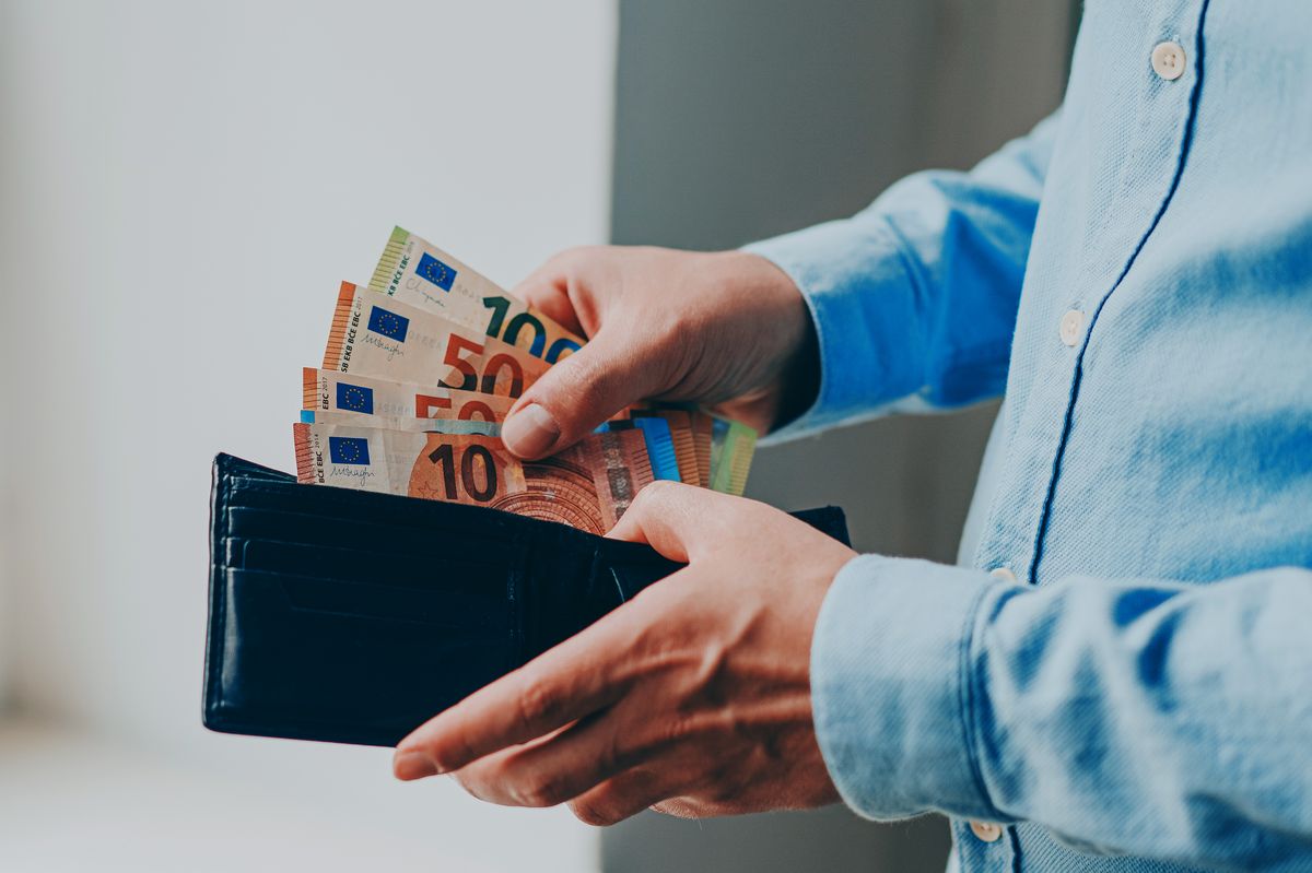 Man taking money out of wallet, European currency