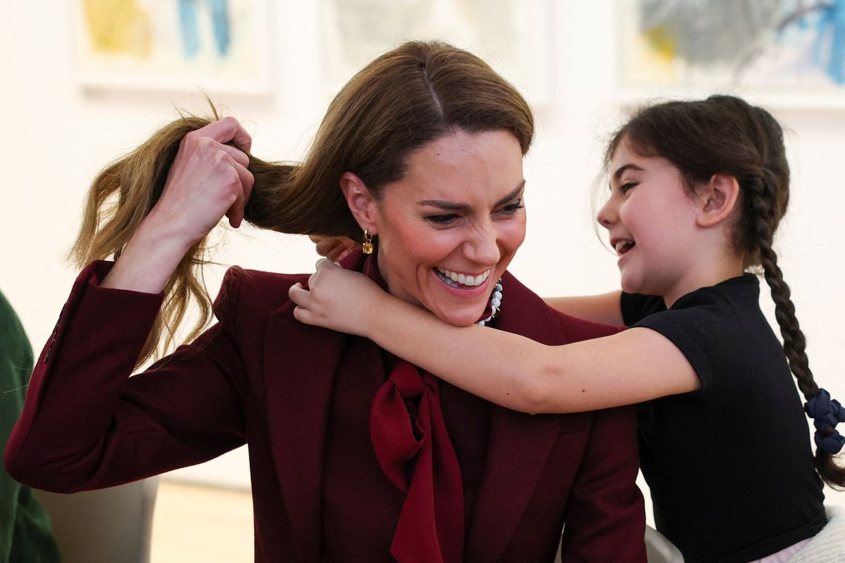 Kate receives a necklace from a little girl at the Oriel Davies art gallery