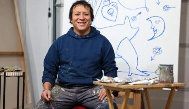 Ernesto "Neto" Atkinson poses in front of a painting he’s working on in his studio. (Photo by Jonathan Aguilar / Milwaukee Neighborhood News Service / CatchLight Local)