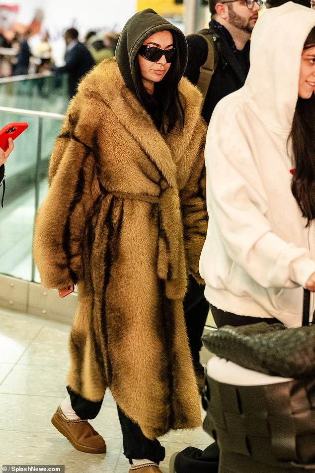 Charli XCX wrapped up in a fur coat as she landed in London on Wednesday after flying in from New York - following backlash to Jason Bateman grilling her on not wanting children