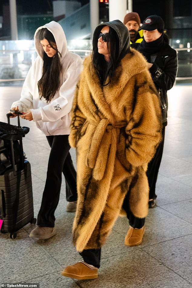 Charli paired the look with casual UGG boot mules and black tracksuit bottoms, as well as covering her eyes with visor sunglasses