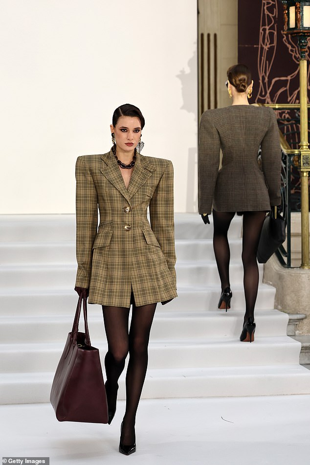 Another model wore a plaid mini dress with a large brown handbag