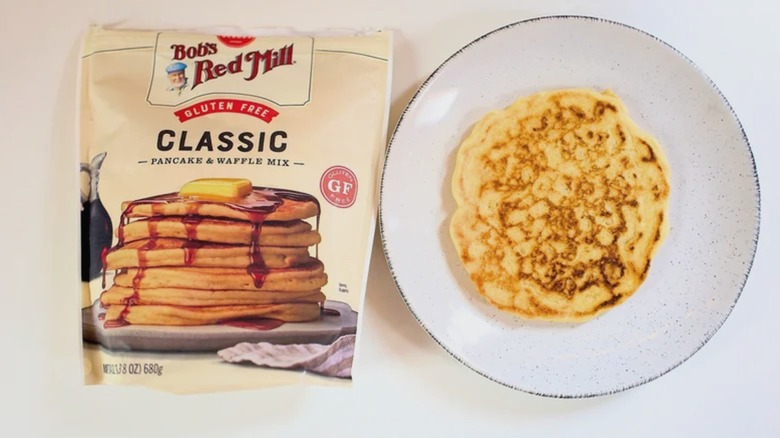 Bag of Bob's Red Mill Gluten Free pancake mix on table next to pancake on plate