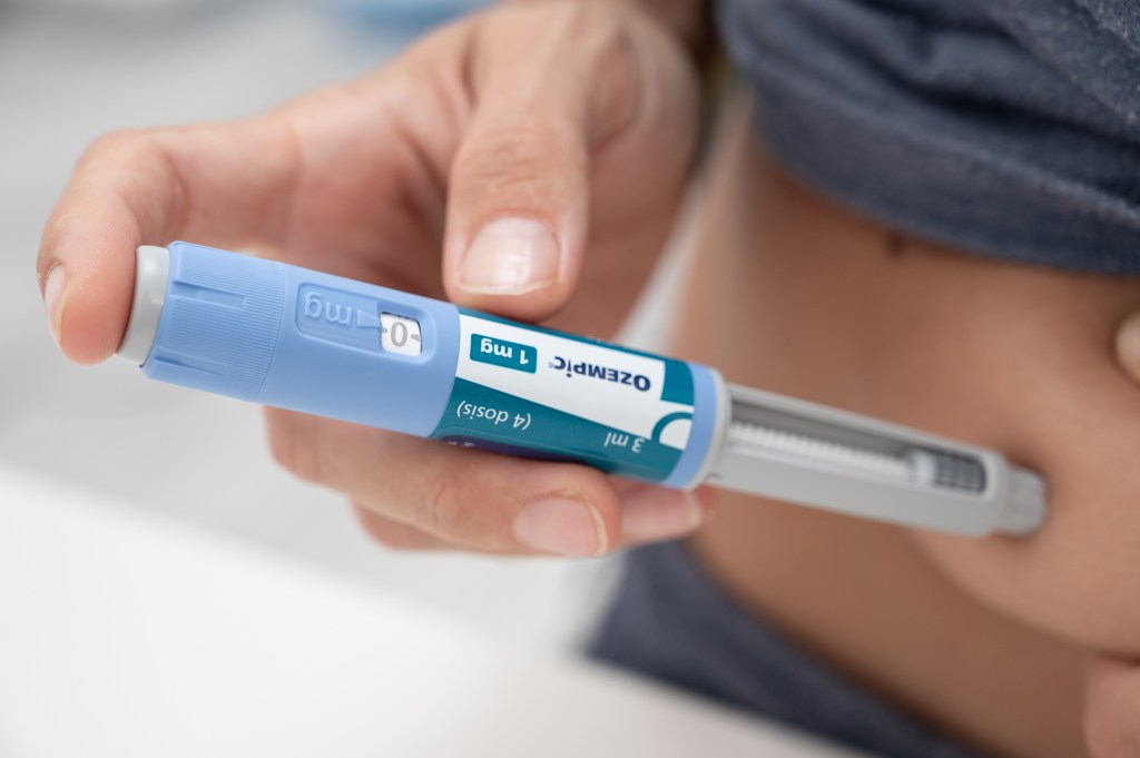 A person injecting Ozempic (semaglutide) into their abdomen for diabetes and weight loss treatment.