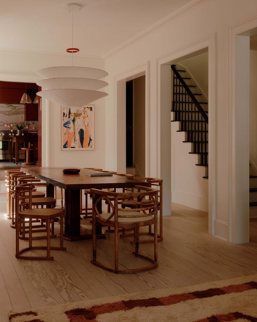 Dining area with a wooden table, chairs, and a pendant light.