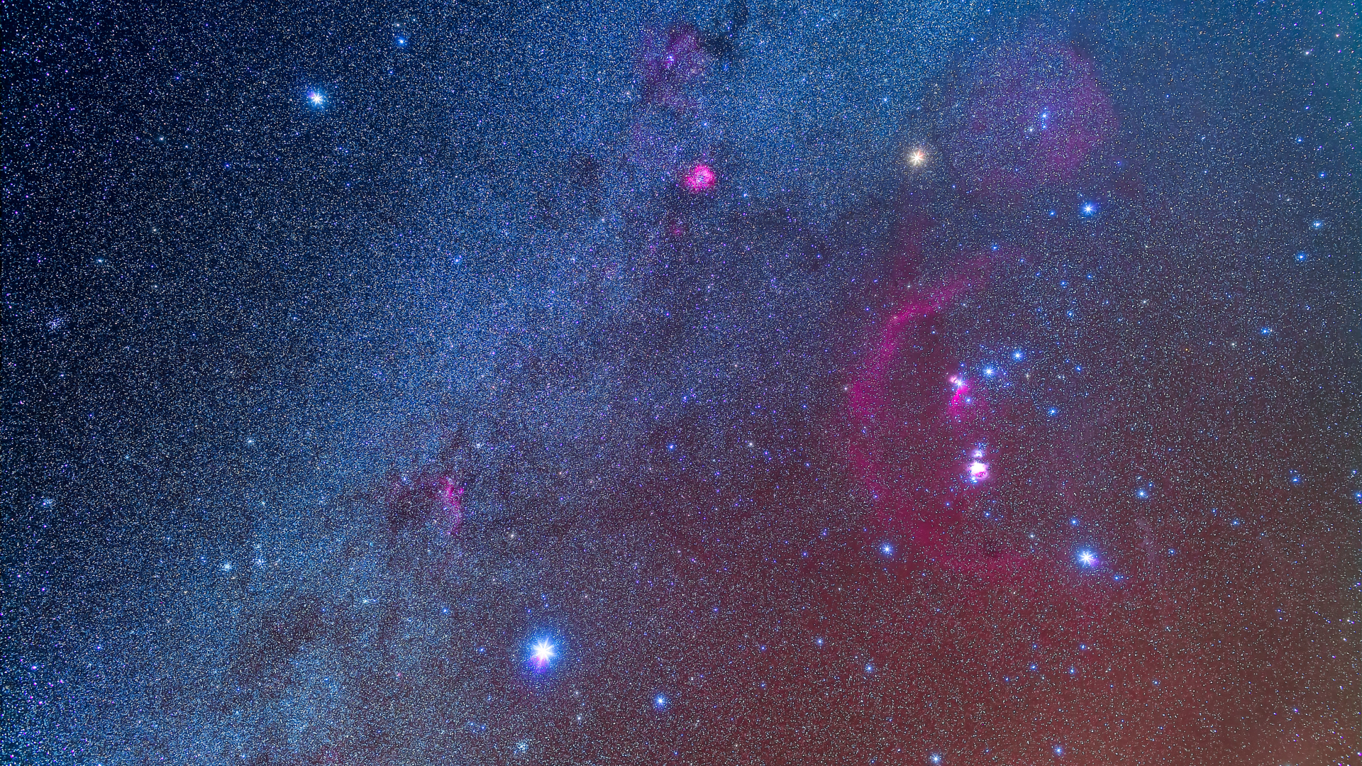 Prominent stars shine alongside the glowing band of the Milky Way in the night sky, which can be seen travelling diagonally right-to-left through the image. The bright stars of the constellation Orion are visible to the right of the Milky Way.