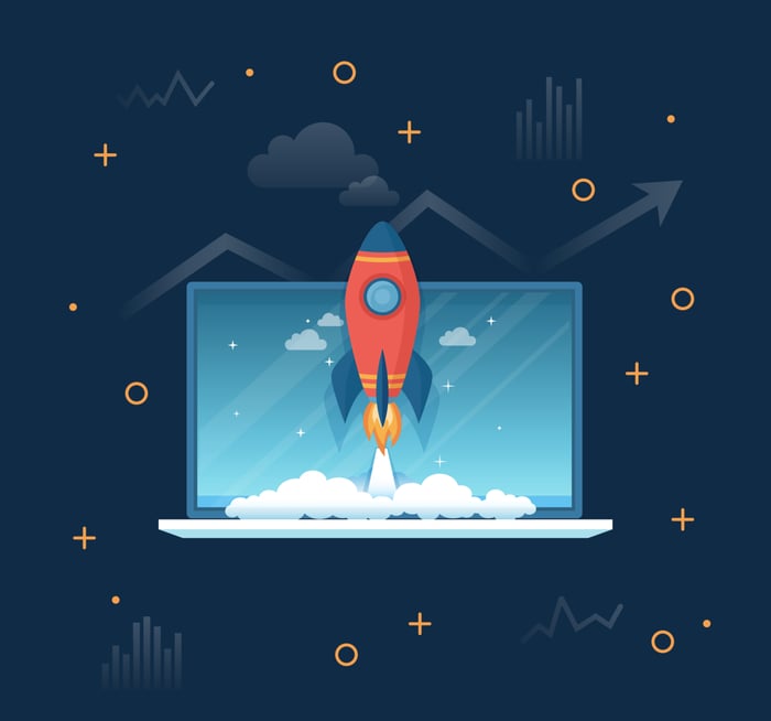 Cartoon rocket ship taking off from laptop.