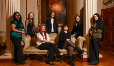 Group of young women pose in formal setting