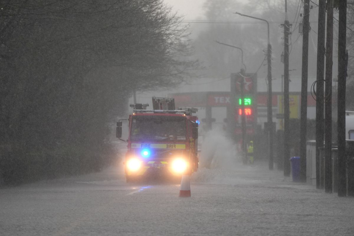 A fire engine drives through a flooded road in Bunclody, Co Wexford as Storm Chandra batters Ireland