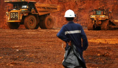 A worker watches as trucks load up raw nickel near Sorowako, South Sulawesi.