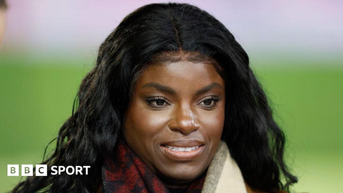 Eni Aluko smiles on the touchline while conducting punditry for TNT Sports during a Premier League match