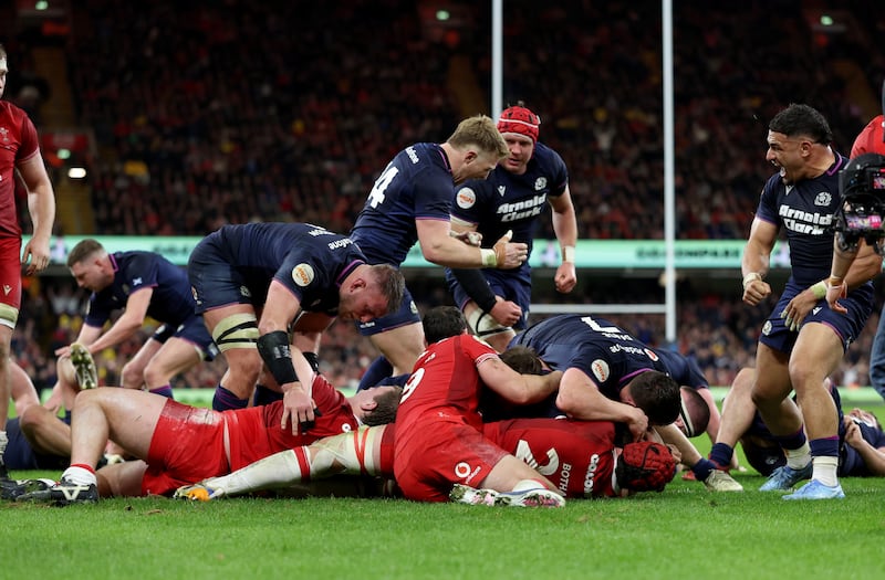 Scotland's players celebrate as George Turner (obscured) scores his side's fourth try in Cardiff. Photograph: Nigel French/PA Wire