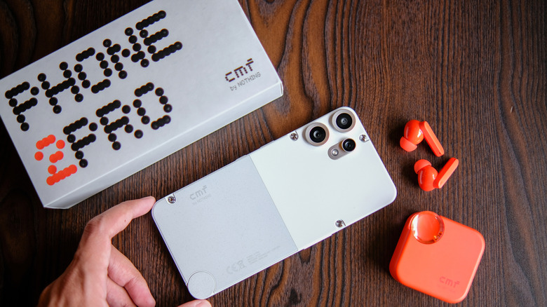 CMF 2 pro phone alongside its box and a pare or orange Nothing earbuds