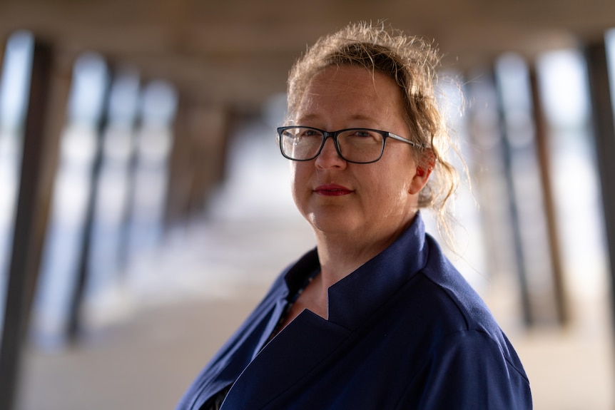 A woman standing beneath a jetty.
