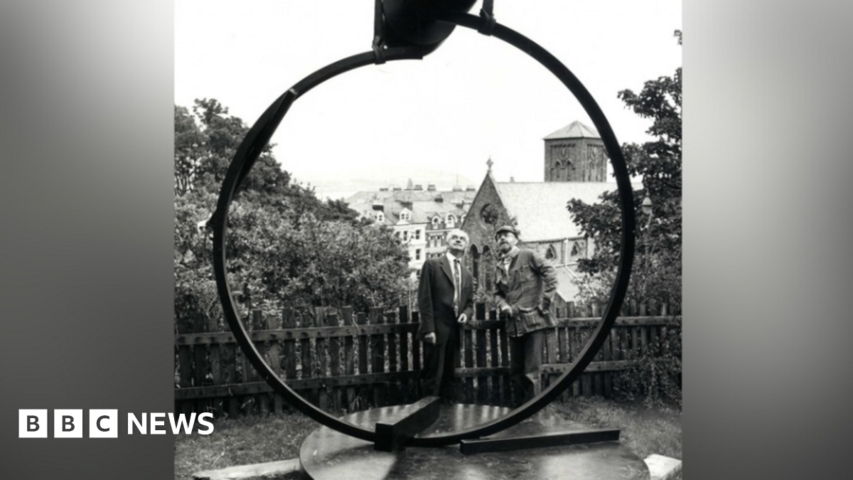 Yn Arreyder is a large steel ring twisted to hold aloft a heavy double dome, positioned to look out across Douglas Bay towards the sunrise.