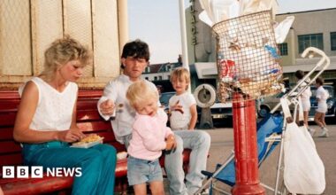 A 1980s photo of a family eating fish and chips, with piles of paper rubbish in the foreground