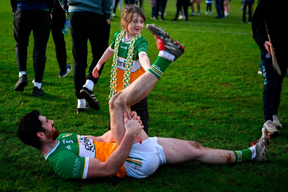Ben Conneely of Offaly has his leg stretched out by his daughter Lia Dán after his side's defeat in the Division 1A match against Waterford at Azzuri Walsh Park. Photo by Shauna Clinton/Sportsfile