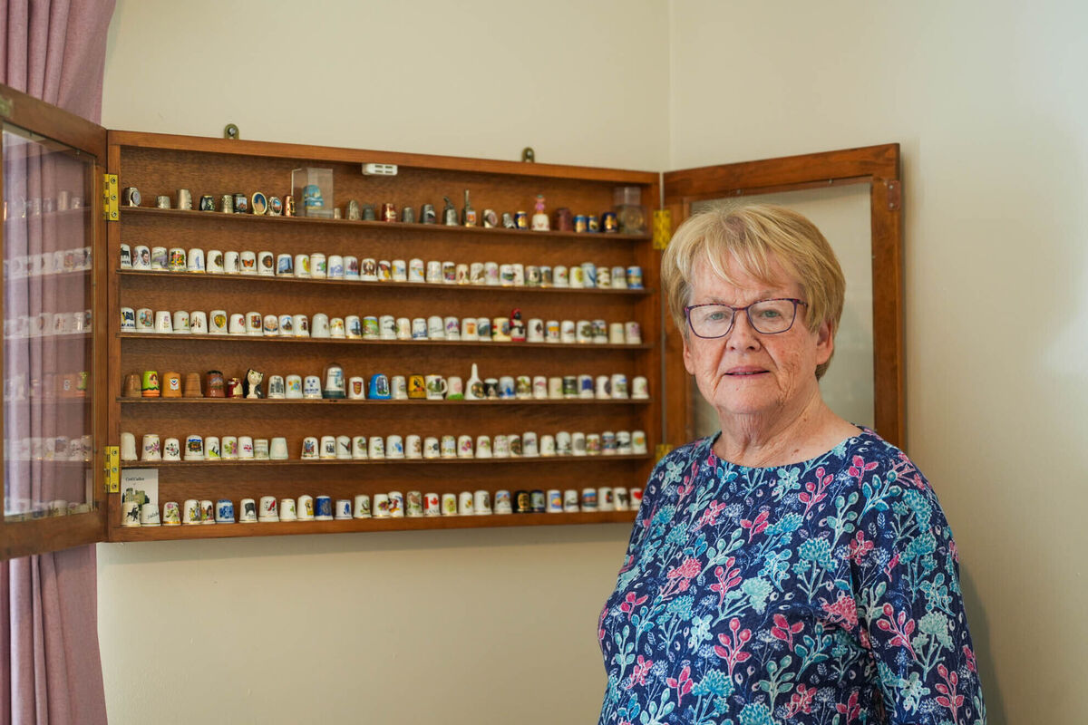 Carmel next to her wall-mounted shelf, where she stores her collection. Picture by Noel Sweeney
