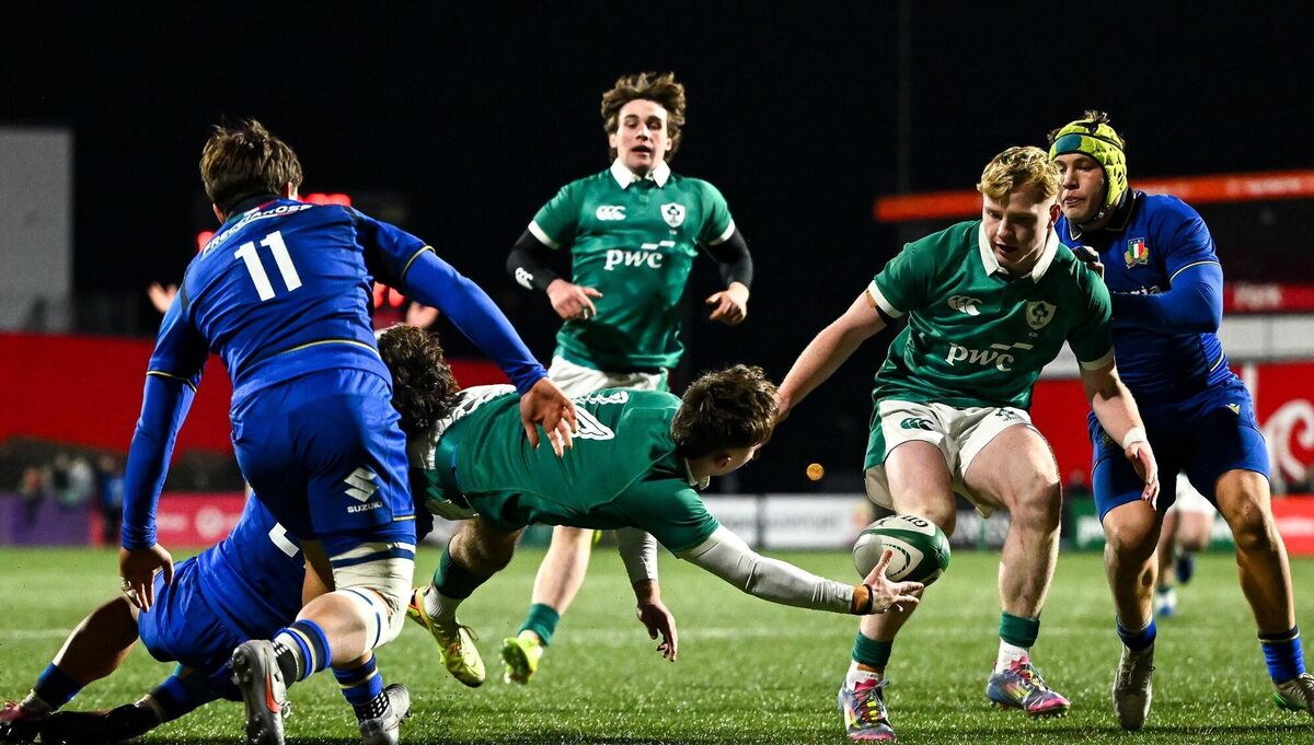 Derry Moloney offloads the ball to team-mate Rob Carney despite the tackle of Nikolaj Varotto of Italy. Pic: Shauna Clinton/Sportsfile