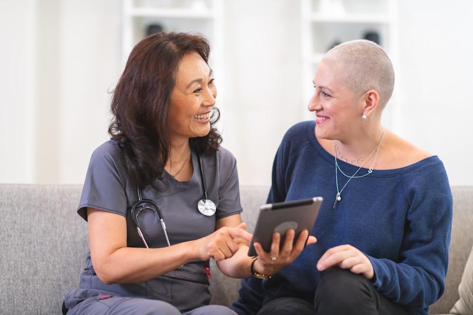 Medical professional consults with patient while sitting on a couch. 