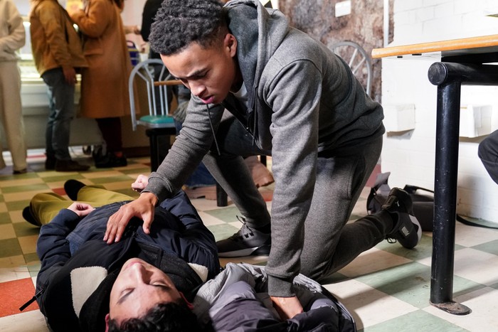 550935,TITLE:Eastenders Denzel stands over Nugget, who is seizing on the floor, in a scene from EastEnders