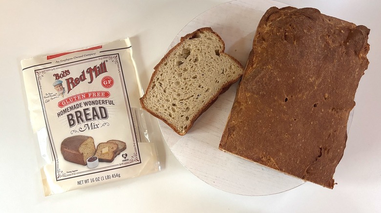 Bag of Bob's Red Mill Gluten Free homemade wonderful bread mix on table next to loaf and slice of bread