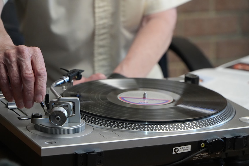 hand on record player arm