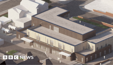 A computer-generated aerial view shows a modern, flat-roofed three-storey healthcare facility.