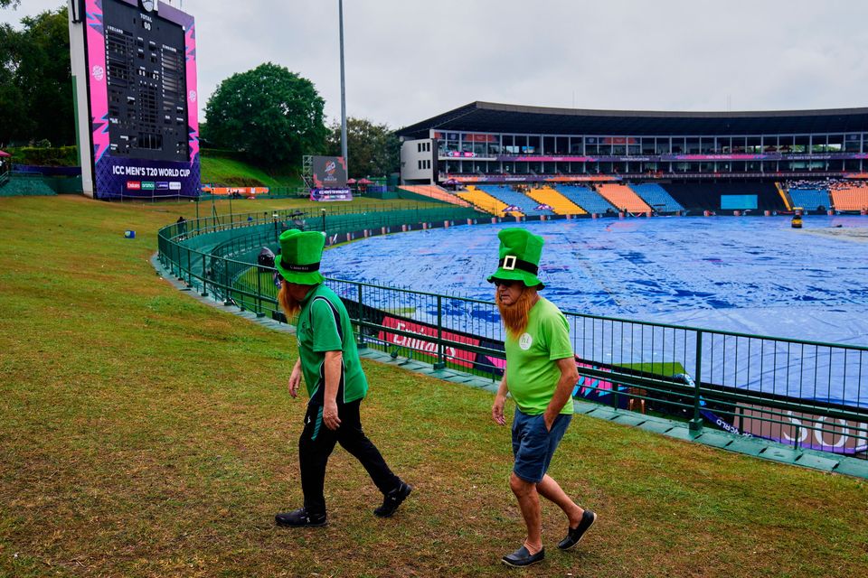 Irish fans walk by the covered ground before the cancelled T20 World Cup cricket match between Ireland and Zimbabwe in Pallekele, Sri Lanka today. Photo: AP Photo/Eranga Jayawardena