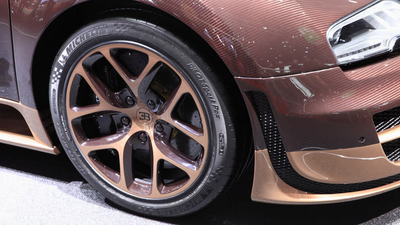 A close-up of a brown Bugatti Veyron sporting Michelin PAX tires.