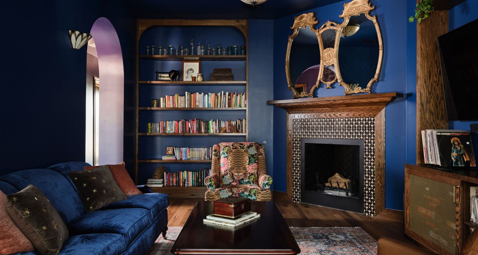 dark blue living room with wood fireplace and dark blue sofa