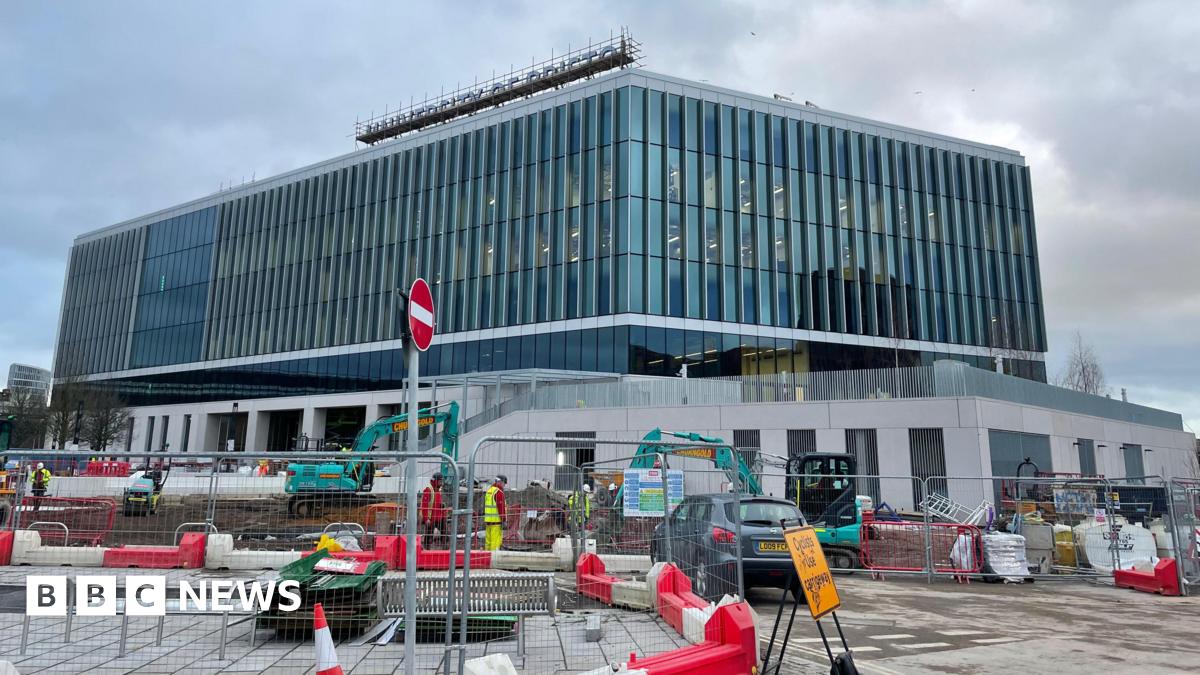 The University of Bristol, Temple Quarter Enterprise Campus in Bristol. It is a very large modern-looking building with glass frontage and a University of Bristol sign on the top. In the foreground is construction work on the building.