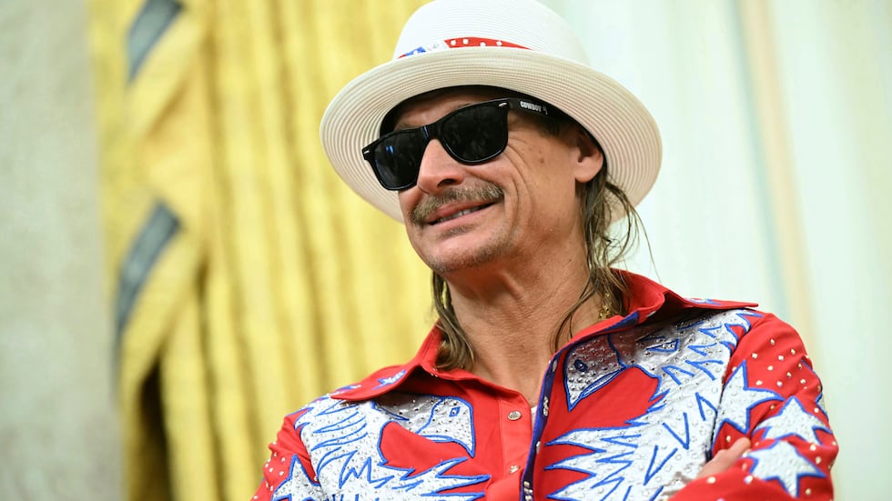 Kid Rock listens as President Donald Trump speaks to reporters before signing an executive...