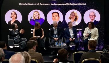 Five people sitting on a panel with their photos behind, three women, two men.
