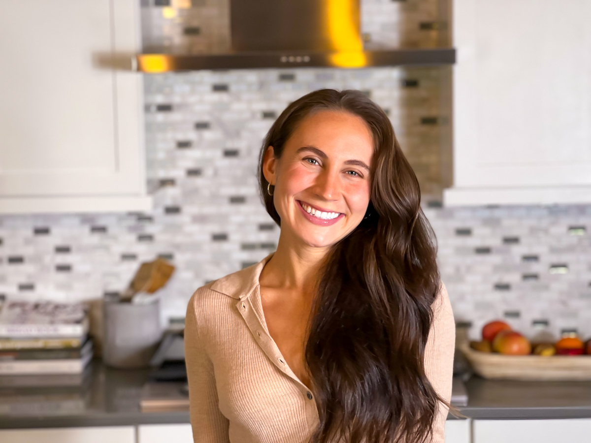 Emmy Clinton smiling in her home kitchen