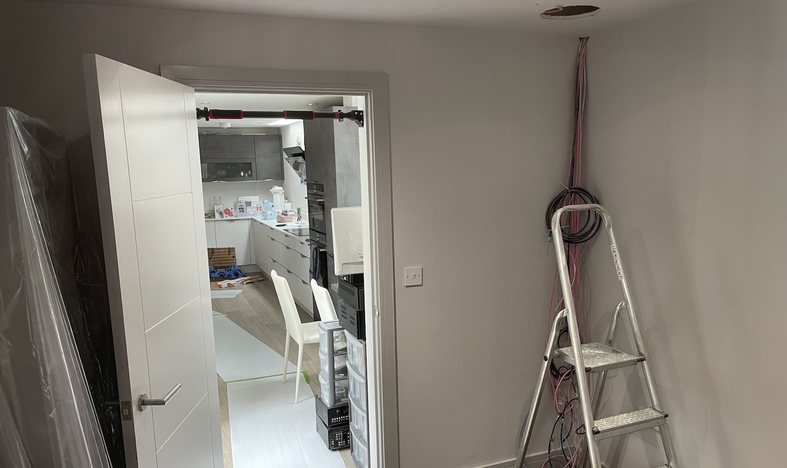 A photo of the back wall of a dedicated home cinema room mid-project, showing cables dangling from the ceiling