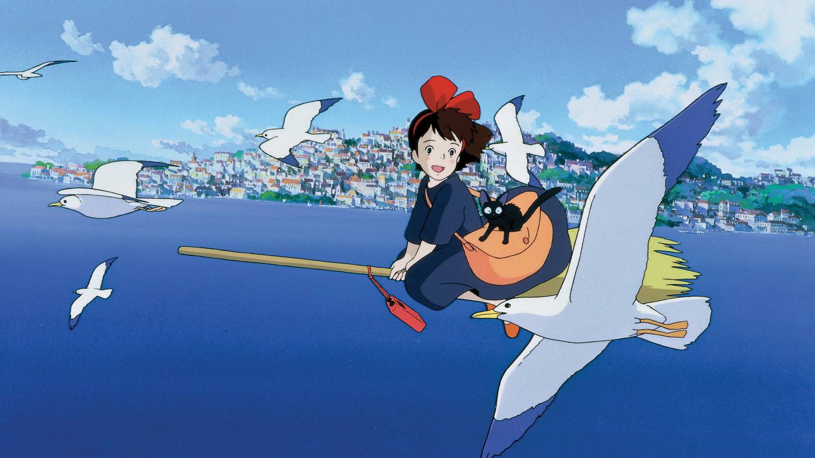 Kiki flying her broomstick over the sea in the animated movie Kiki’s Delivery Service.