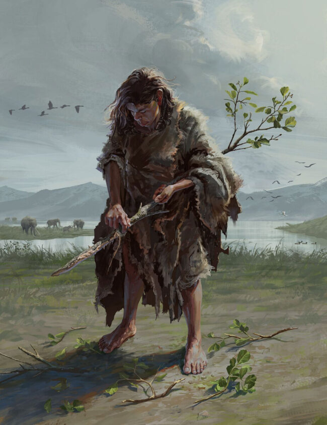 Scruffy-looking standing woman wrapped in ragged pelts holding and whittling on a straight sapling.