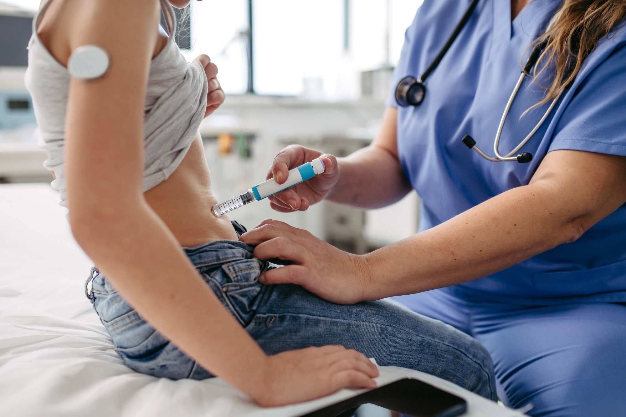 Nurse injecting insulin in diabetic girl belly. Close up of young girl with type 1 diabetes taking insulin with syringe needle.