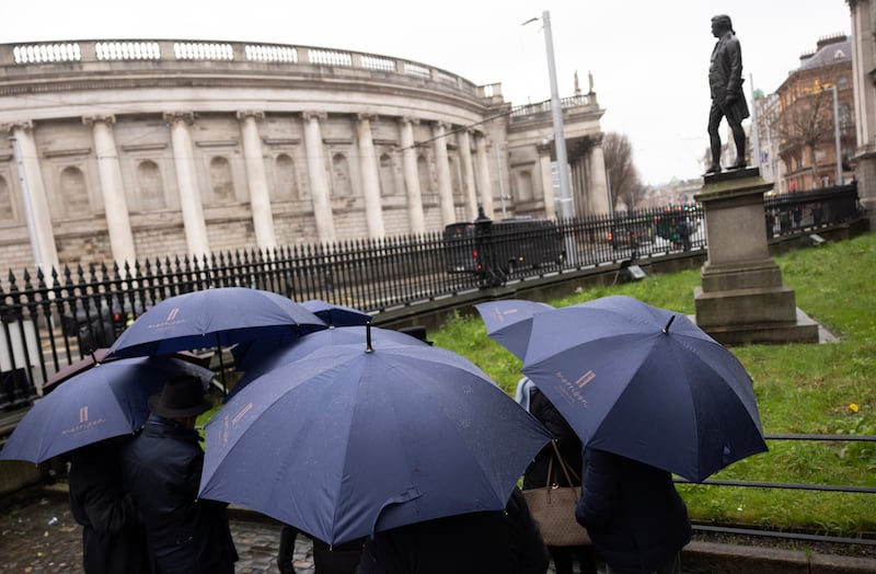 Tourists gather at the gates of Trinity as orange and yellow rain warnings are in place for several counties - with Met Éireann again warning of flooding. Photograph: Chris Maddaloni/The Irish Times 