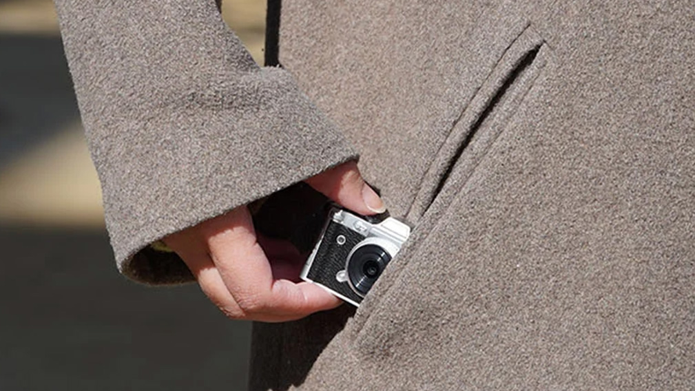 The Haru Mini Retro camera being placed in a coat pocket