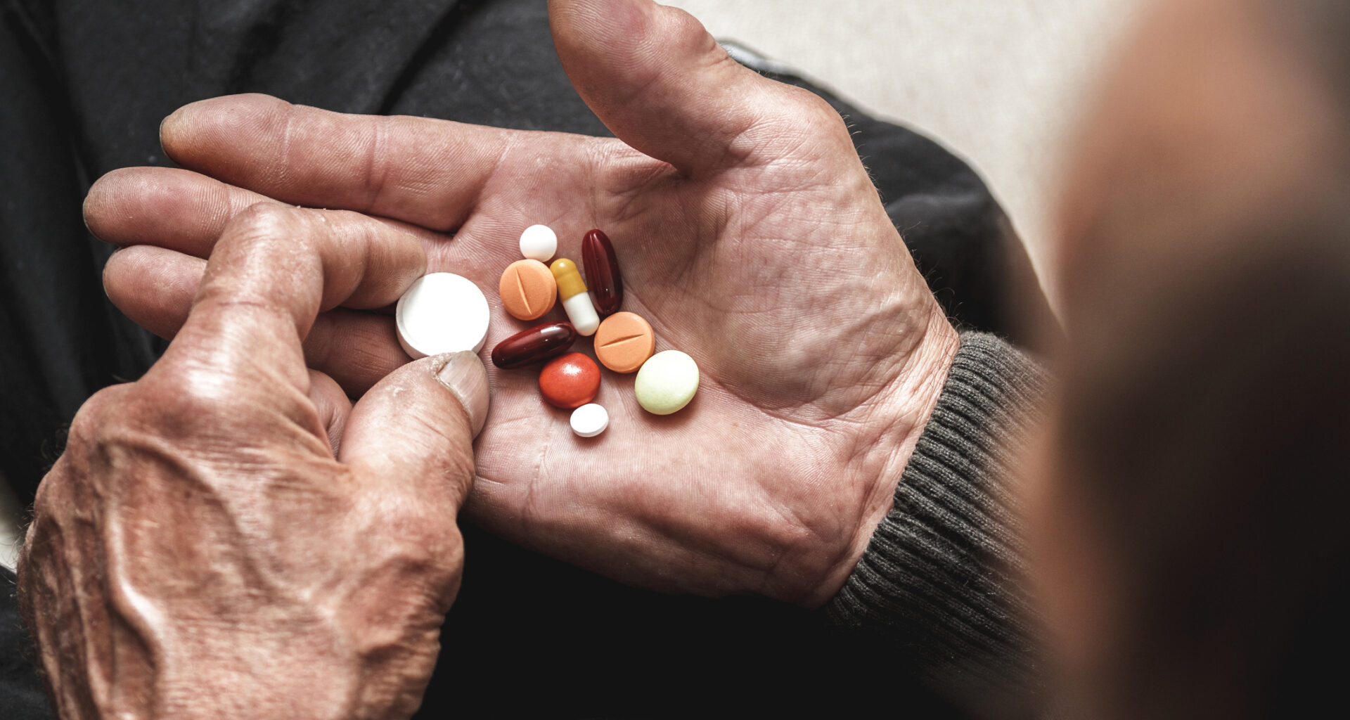 Assorted tablets in hands of elderly man