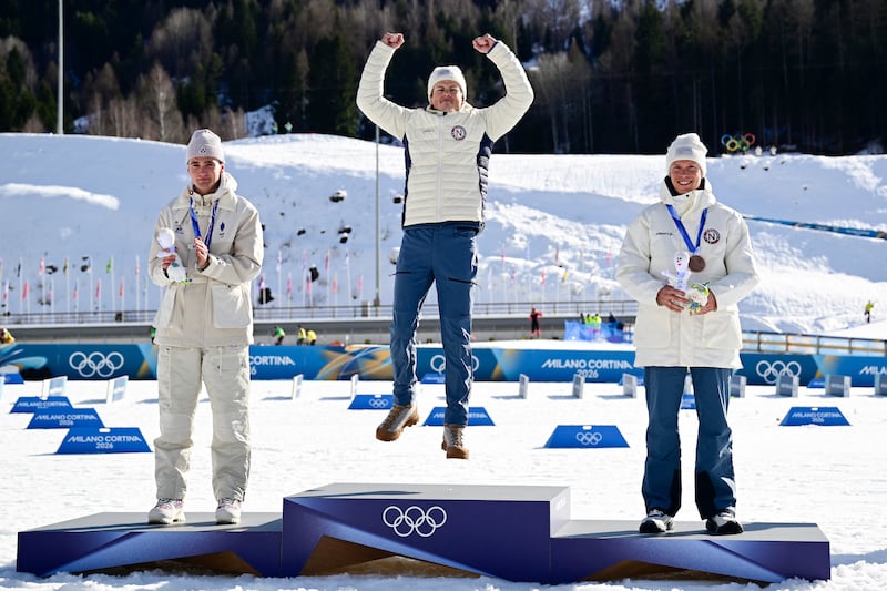 Gold medallist Johannes Høsflot Klæbo from Norway celebrates on the podium along with silver medal winner Mathis Desloges from France (left) and bronze medal winner Martin Løwstrøm Nyenget from Norway. Photograph: Tobias Schwarz/AFP via Getty Images