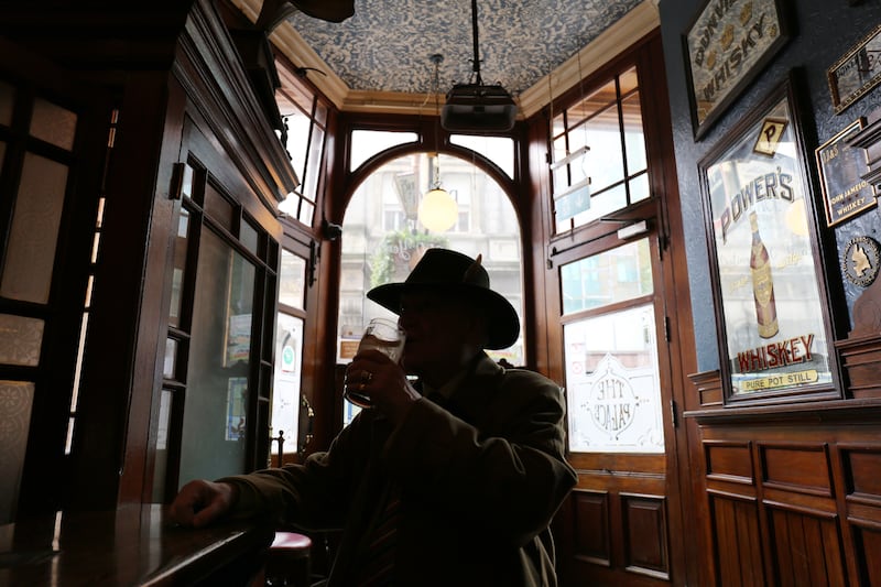 A customer enjoys a drink in the Palace Bar. Photograph: Bryan O’Brien