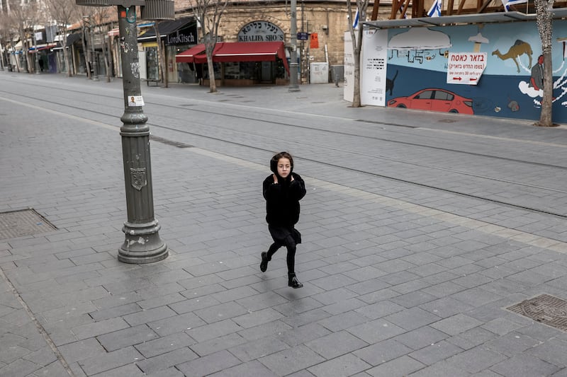 A girl runs along a street as sirens sound in Jerusalem on Saturday. Photograph: John Wessels/AFP via Getty Images